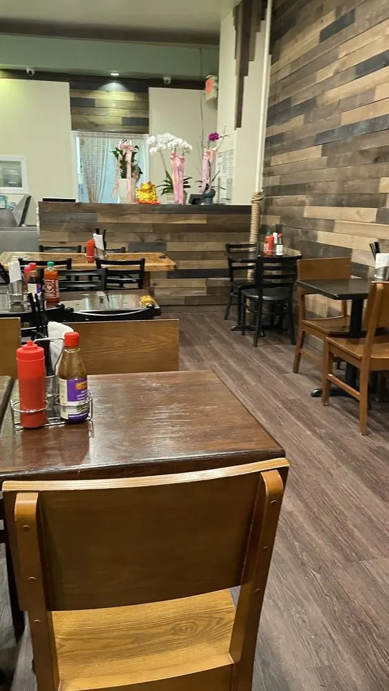 Dining room with wood tables, wood plank wall, and condiments on each table