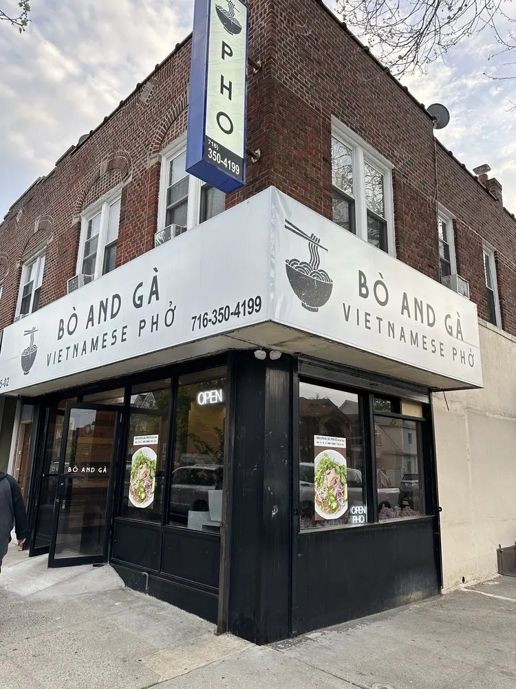 Corner storefront of Bò and Gà with its white sign, black window frames, and a blue vertical PHO blade sign