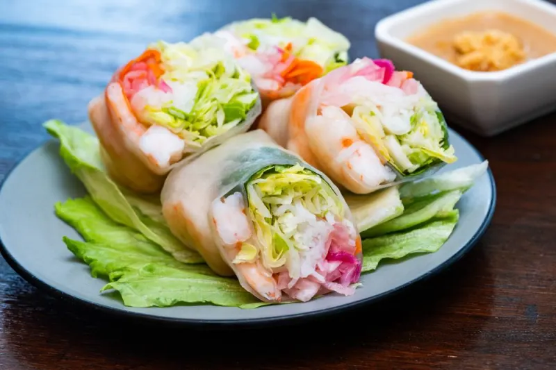 Shrimp summer rolls on lettuce with peanut sauce